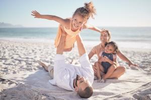 bon-voyage-en-famille-et-vacances-a-la-plage-avec-des-enfants-et-des-parents-jouant-ensemble-dans-le-sable