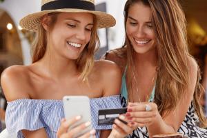 meilleures-amies-les-femmes-se-reunissent-a-la-cafeteria-heureuses-de-faire-des-achats-en-ligne-avec-un-telephone-intelligent-et-une-carte-en-plastique