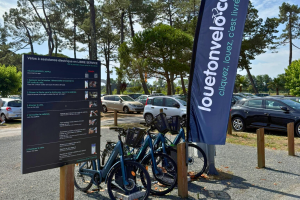 Boutique Louetonvelo sur la place centrale du village du meilleur camping du Sud-Ouest, proposant la location de vélos et accessoires dans une ambiance conviviale et estivale.