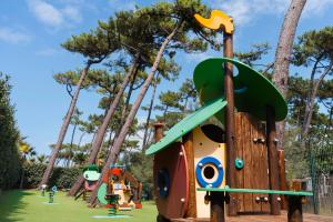 Aire de jeux pour les enfants de 2 à 6 ans avec un revêtement anti-choc coloré, située à côté de l'espace fitness et de l'accès à la plage au camping, offrant un environnement sécurisé et ludique en bord de mer