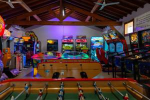 Salle de jeux et d’arcade moderne située dans un camping en bord de mer dans les Landes, équipée de bornes d’arcade, de billards, de baby-foot et de jeux interactifs pour petits et grands, offrant un espace convivial et divertissant à quelques pas de l’océan.