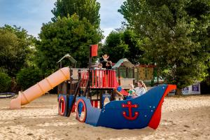 couple de 2 parents avec leurs deux enfants dans le bateau bleu du camping avec toboggan Un équilibre parfait pour vos enfants et vous Des jeux en extérieur pour children actifs et heureux