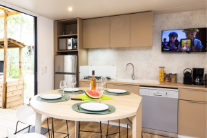 Téléviseur moderne de taille moyenne dans la salle à manger du mobil-home, avec une image animation pour enfants de dessin animé miraculous affiché à l’écran
