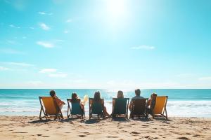 Six amis se relaxant sur des transats de plage en regardant l'ocean avec à l'horizon une mer d'huile et de grandes étendues de sable fin tout autour comme s'ils étaient au paradis des vacances