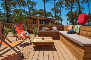 Espace bar privé de la terrasse all-in-one tout inclus du modèle key west cottage suite premium jacuzzi 8 personnes 4 chambres avec bains de soleil, bancs cosy et table chill pour profiter des meilleurs moment du camping en bord de plage