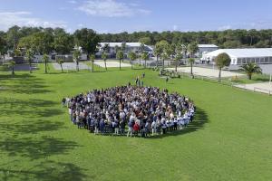 Photo drone vue aérienne 500 personnes en formation ronde cercle terrain football événement team building