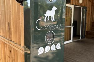 Photo boîte métal sacs déjection canine gratuites laveries camping : distributeur propreté chien dog-friendly, accès sacs ramasse-crottes offert, hygiène zones communes pins Landes.