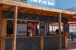Photo gros plan comptoir The Pool Bar parc aquatique : plan de travail carrelé splash cocktails glaces paninis, service restauration rapide bassin, détail bar aquatique convivial.