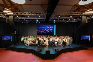Photo de groupe d'une conférence de plus de 100 personnes en train de poser pour immortaliser leur présence à leur événément professionnel d'entreprise