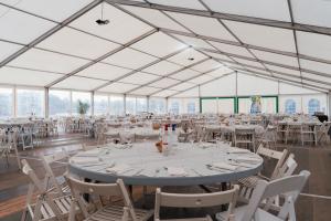 Tables rondes bien dressées sous le chapiteau du Vieux Port : nappage élégant, vaisselle et décoration soignée pour une réception, un repas d’entreprise ou un événement convivial.