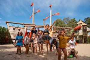 Enfants en vacances jouant sur les structures de jeux de l’aire de jeux Kids, les pieds dans le sable