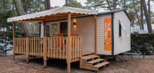 Terrasse ensoleillée avec mobilier de jardin devant un mobil home dans un camping en bord de mer dans les Landes