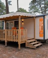 Terrasse ensoleillée avec mobilier de jardin devant un mobil home dans un camping en bord de mer dans les Landes