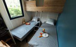 Intérieur chambre avec trois lits simples dont 1 lit mezzanine Cabane Bois 4 personnes du camping 5 étoiles Le Vieux Port à Messanges Vieux Boucau dans les Landes