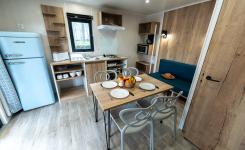 Intérieur avec vue sur la salle à manger cuisine kitchenette dans la Cabane Bois 4 personnes du camping 5 étoiles Le Vieux Port à Messanges Vieux Boucau dans les Landes