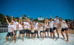 L'équipe d'animation du camping Le Vieux Port au grand complet pose les pieds dans l'eau de la piscine