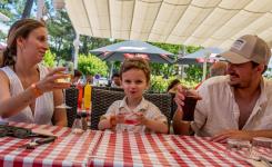 Demi-pension-services-camping-5-etoiles-vieux-port-landes-restaurant-terrasse-couple-avec-enfant-qui-trinquent-aux-vacances