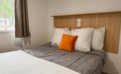 Chambre lit double d'un mobil home en bois cosy pouvant accueillir 4 à 6 personnes, niché sous les pins du littoral landais près de Bayonne et Biarritz