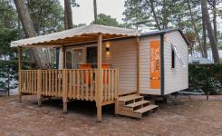 Terrasse ensoleillée avec mobilier de jardin devant un mobil home dans un camping en bord de mer dans les Landes