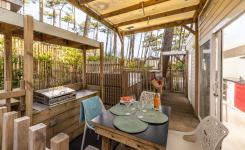 Plancha individuelle moderne et barbecue collectif en plein air au meilleur camping des Landes en bord de mer, installés sur une terrasse conviviale entourée de pins, offrant aux vacanciers un espace agréable pour cuisiner et partager des repas en famille ou entre amis.