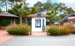 Distributeur automatique de billets Euronet flambant neuf, installé à l’entrée du camping, identifiable par son habillage aux couleurs bleues et jaunes. Le DAB est accessible en libre-service à proximité des installations du camping, permettant aux vacanciers de retirer de l’argent liquide facilement durant leur séjour. 