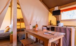 Tente tout confort RESASOL 4/5 personnes : 21 m², ambiance cosy, cuisine équipée, 2 chambres, salle de bains, terrasse couverte.