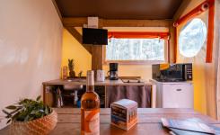 Tente RESASOL 4-5 personnes au camping : 21 m², ambiance cosy, cuisine équipée, 2 chambres, salle de bains, terrasse haute couverte.