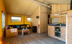 Salon spacieux de la tente Ecoluxe 8 personnes avec canapé et table à manger