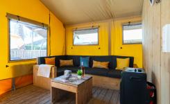 Intérieur tente lodge Ecoluxe 49 m² salon familial camping Landes
