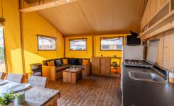 Salon spacieux de la tente Ecoluxe 4/5 personnes avec coin détente et table à manger