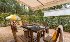 Vue depuis la façade du mobil-home Eco 4 personnes vers la table des repas en location au Camping Le Vieux Port
