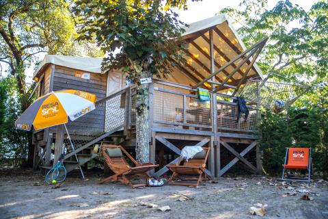Cabane sur pilotis et sa terrasse au camping 5 étoiles Le Vieux Port dans les Landes