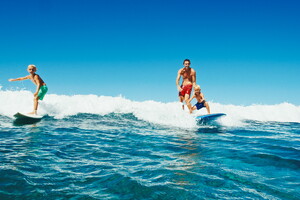 Surf en famille avec un père et ses enfants