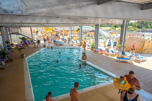 Familles autour de la piscine couverte du parc aquatique du camping 5 étoiles Le Vieux Port dans les Landes